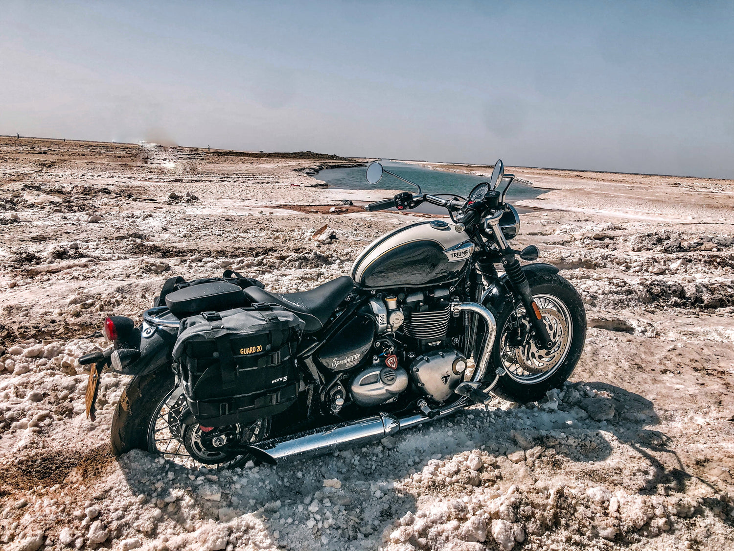 Triumph motorcycle with WESTWIND motorcycle luggage in Sandy beach landscape